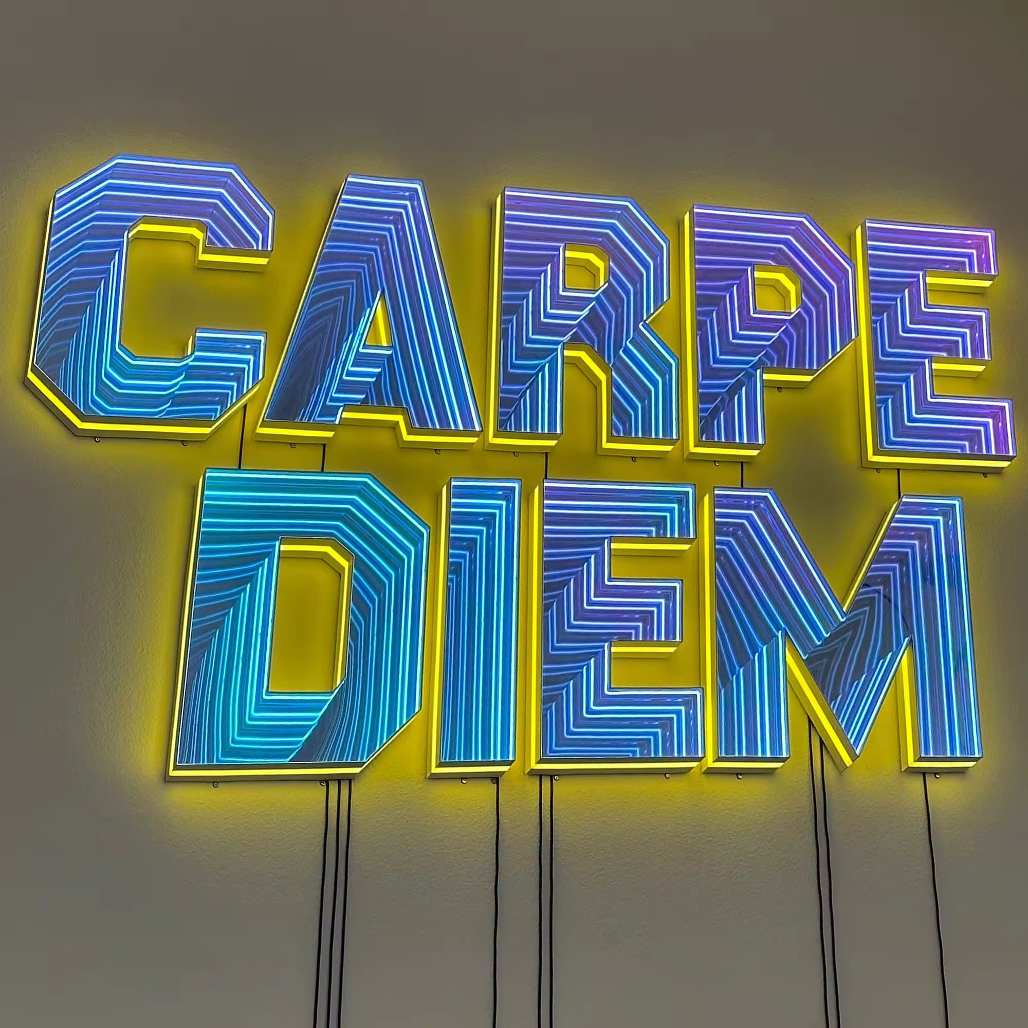 Letter infinity mirror sign in a premium branded interior
